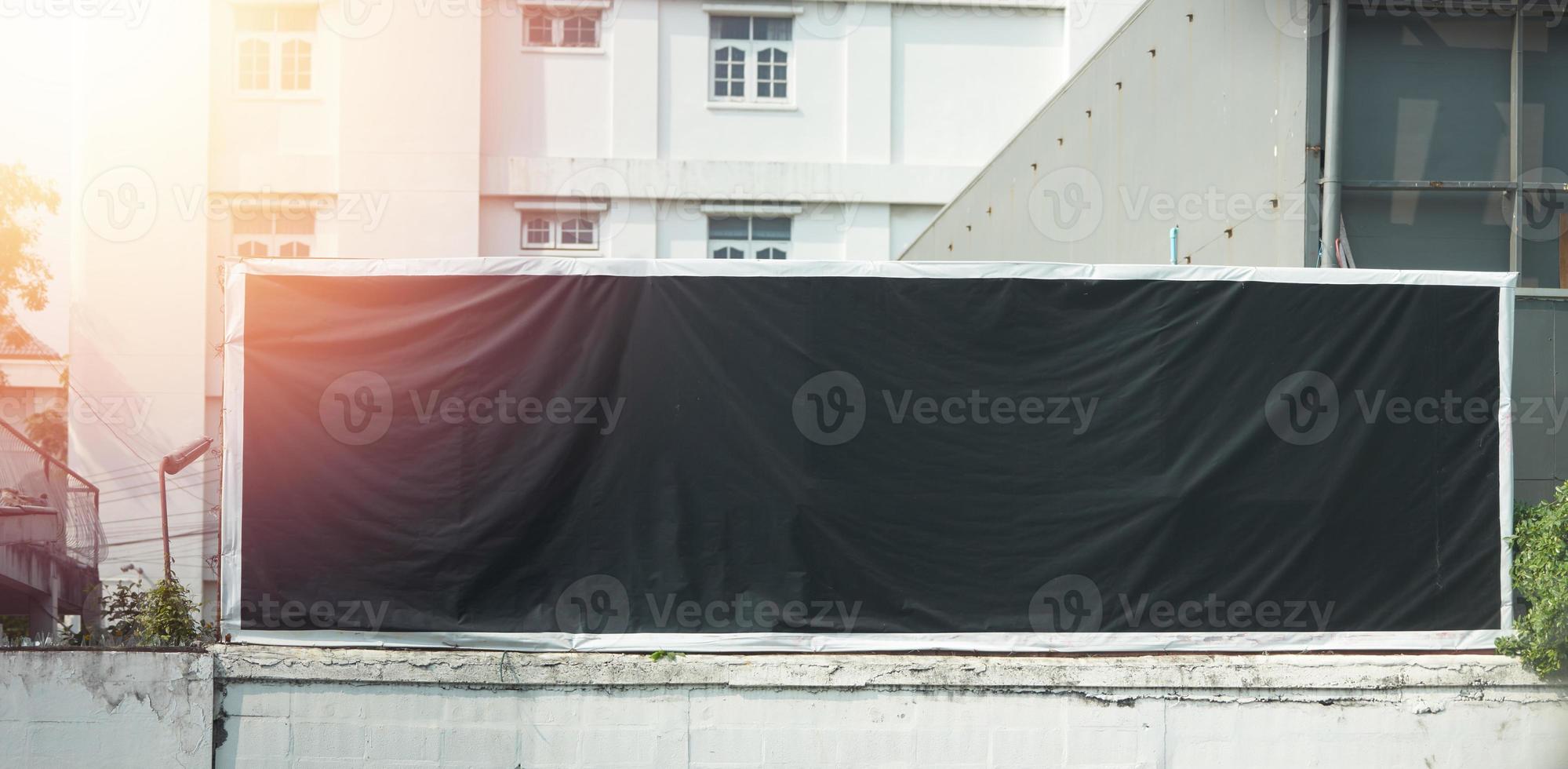 zwarte mock-up billboard op hek op wazige stadsachtergrond foto