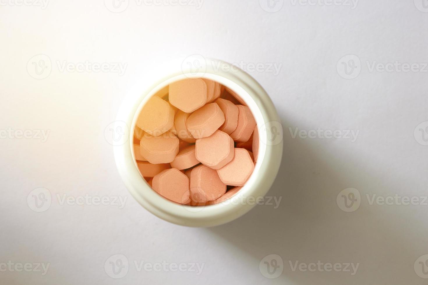 zeshoekige tabletten in witte plastic pot in drogisterijconcept voor medische gezondheidszorg, gesloten foto