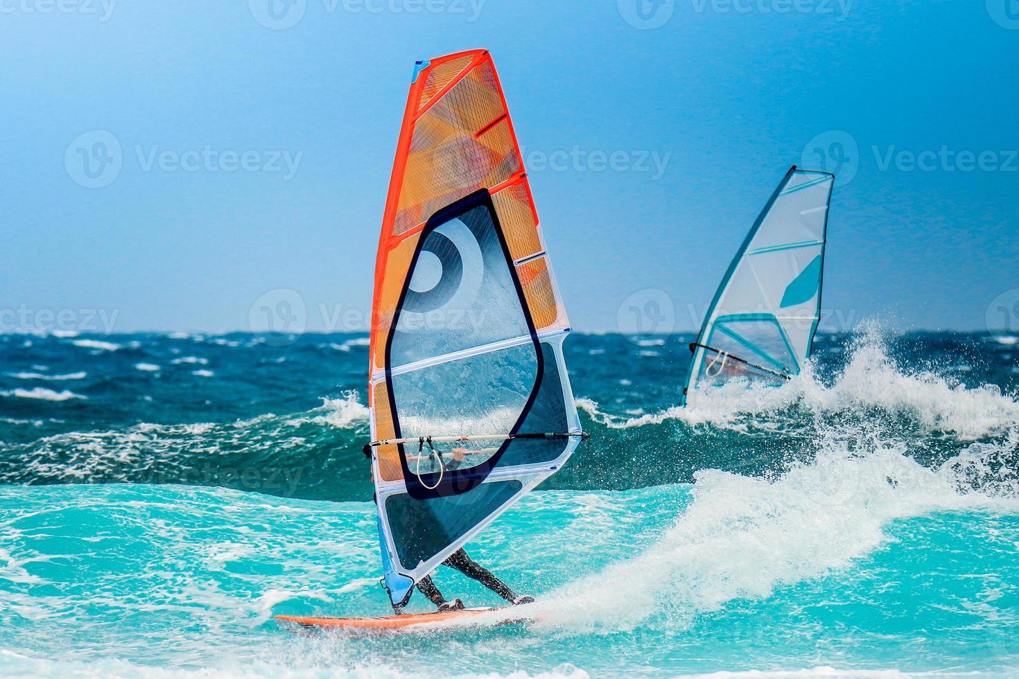 windsurfer rijdt in een golfbuis van de blauwe oceaan tijdens een vakantie foto