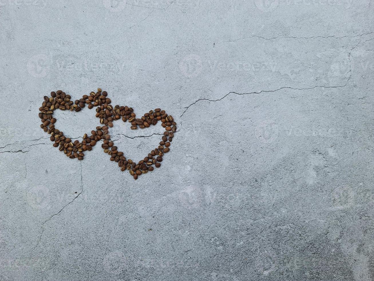 liefde of Valentijn concept. gesloten koffiebonen in hartvorm op geïsoleerde grijze behangachtergrond foto