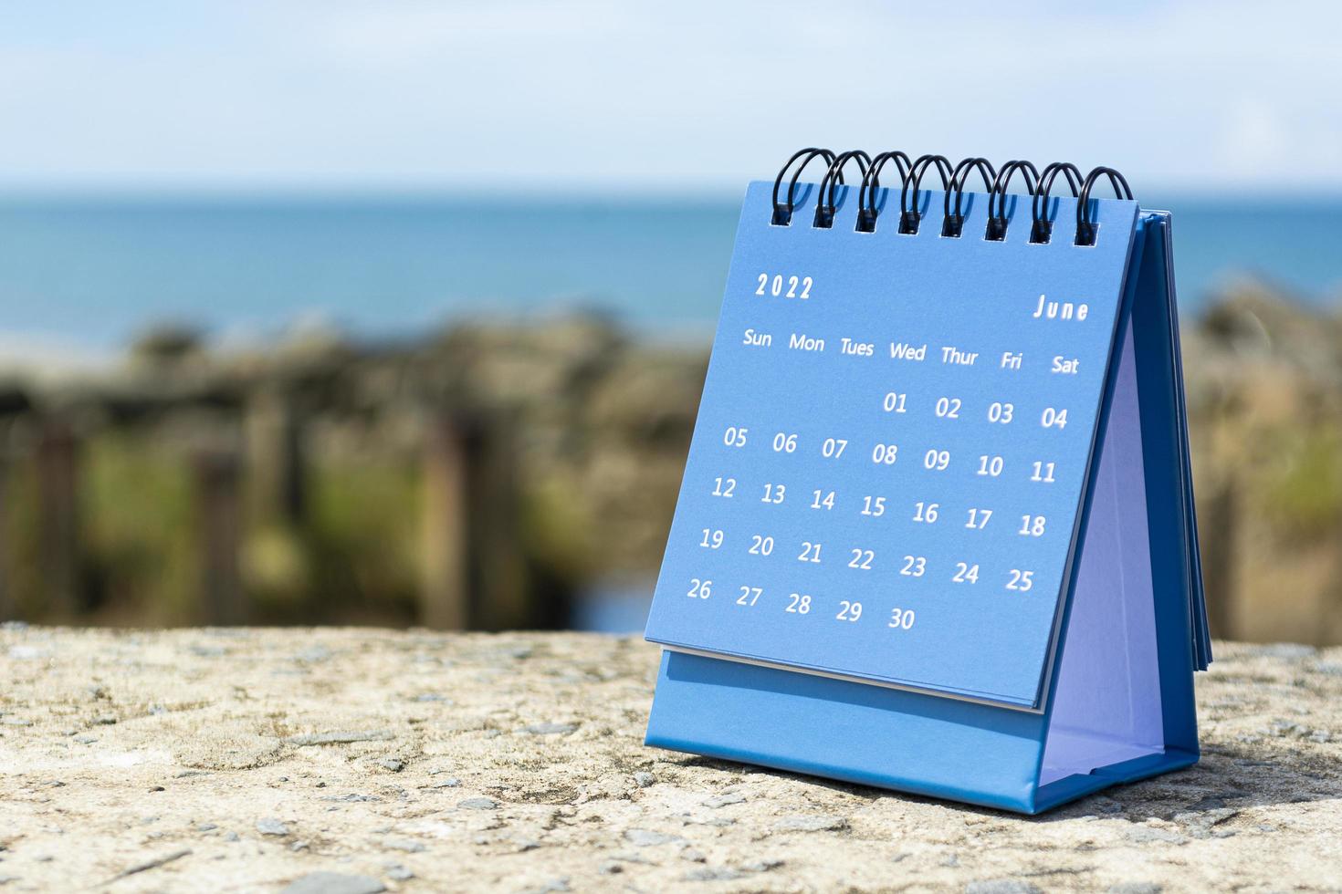 blauwe juni 2022 kalender op onscherpe achtergrond van blauwe oceaan foto