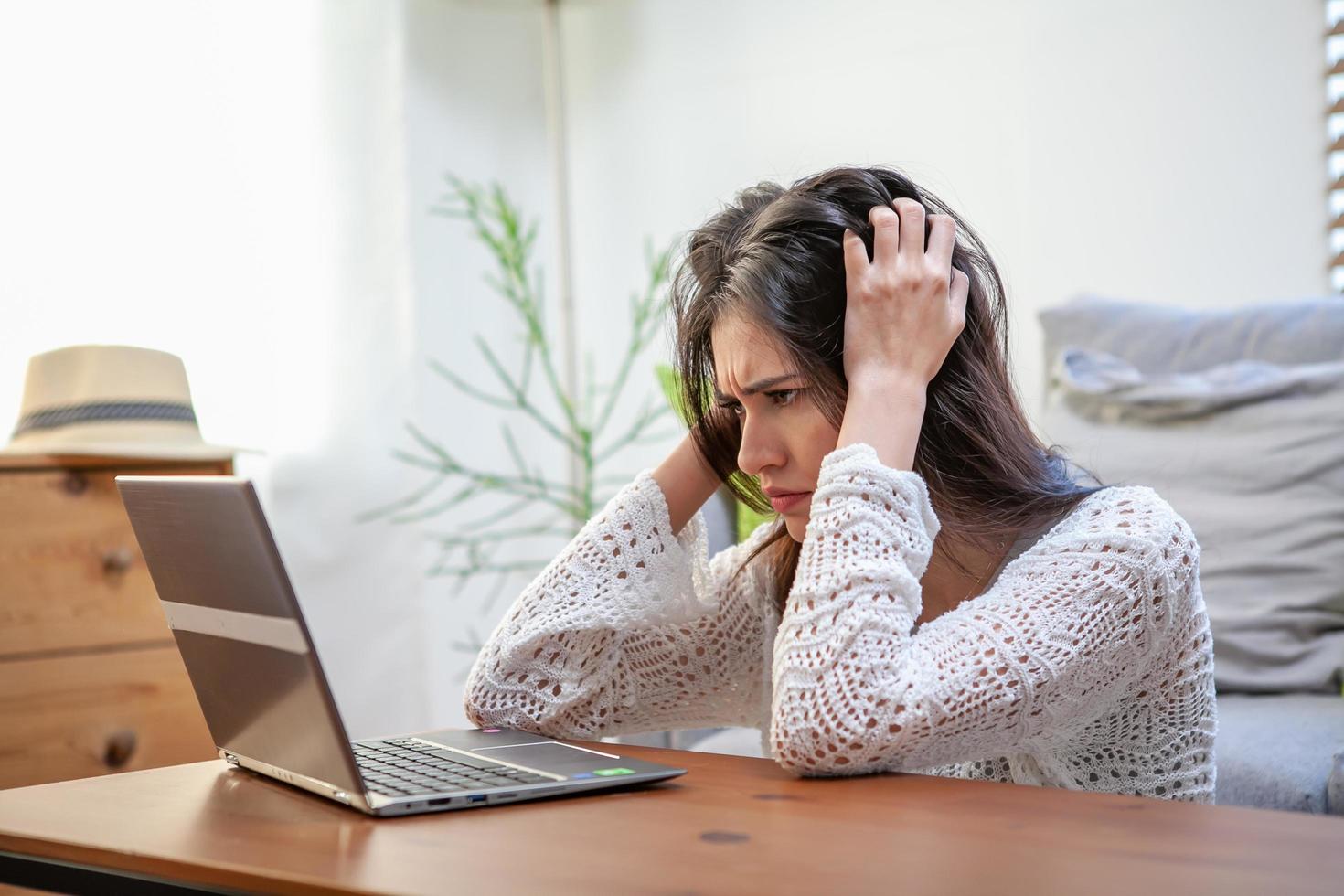 jonge vrouw met laptopcomputer, kantoormedewerker moe en heeft hoofdpijn. foto