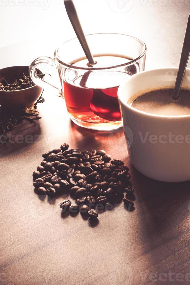 koffie en thee met koffieboon en theeblaadjes op houten vloer. foto