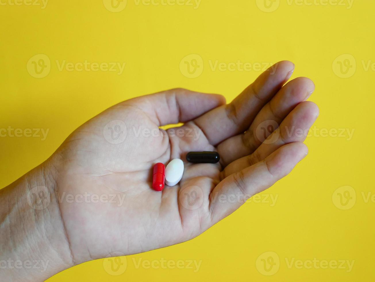 Aziatische vrouwen die capsulepillen in de hand houden foto