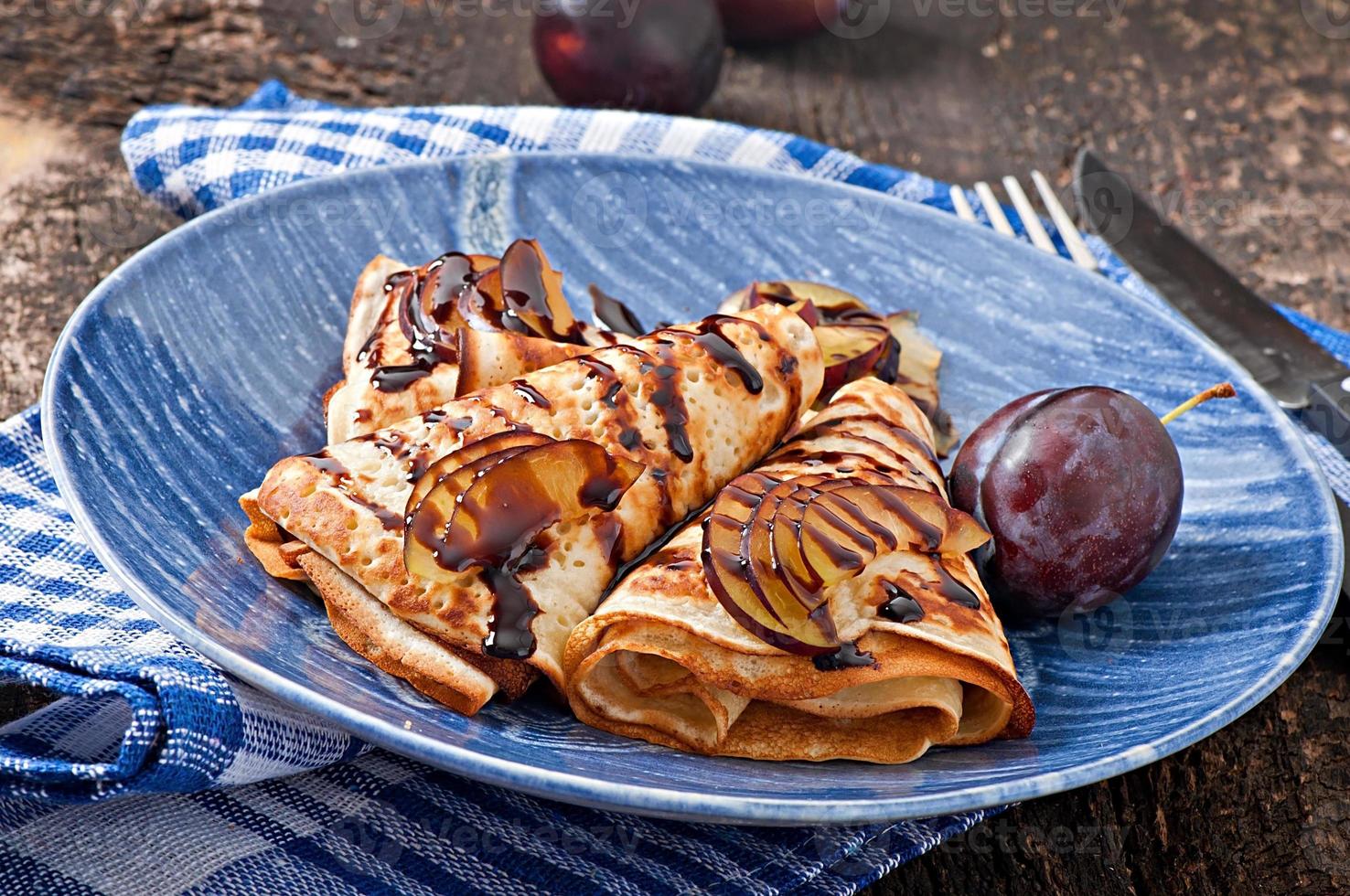 pannenkoeken met chocoladesiroop en pruimen foto