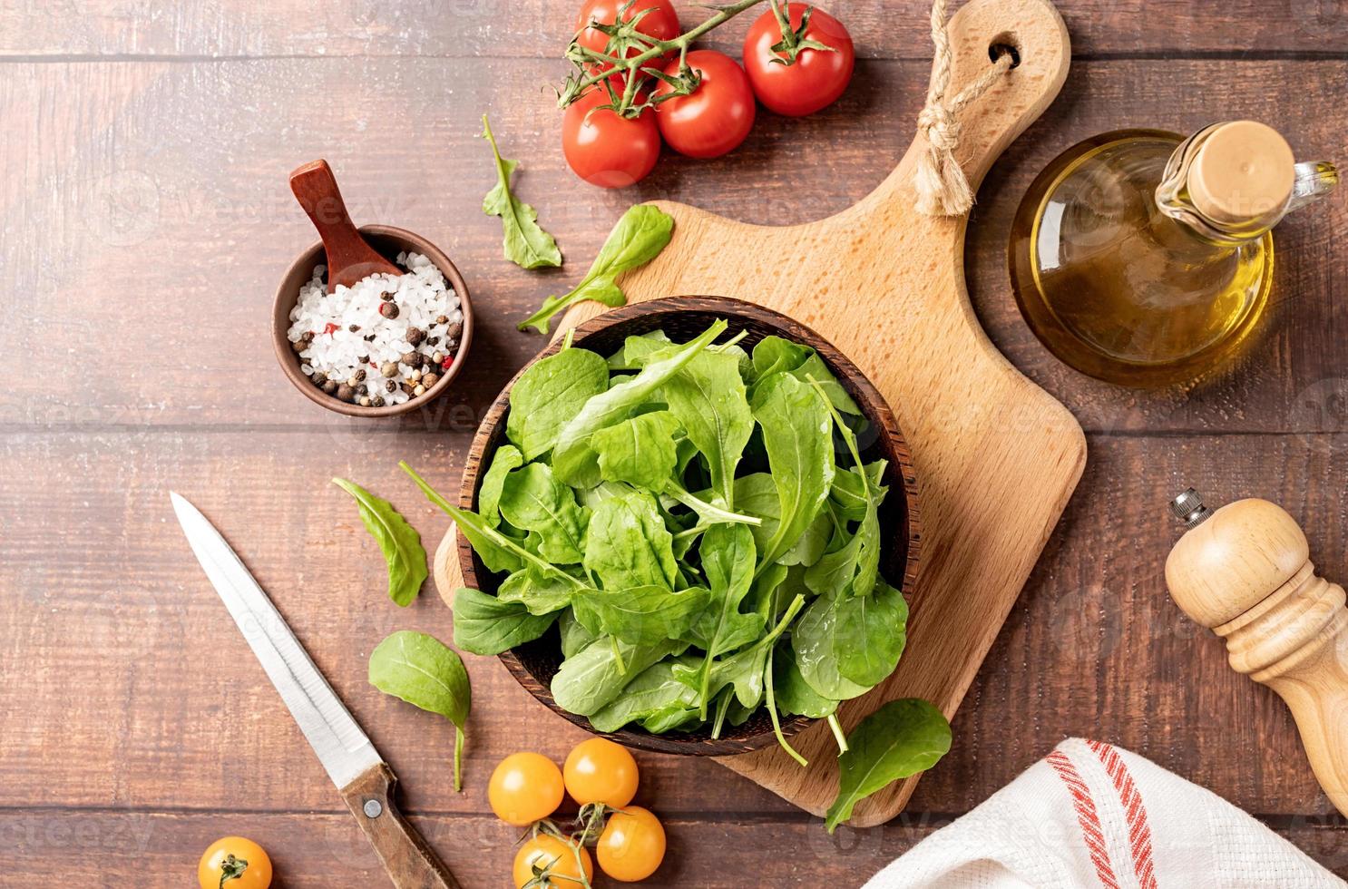 verse rucola bladeren in bruine kom met verse groenten foto