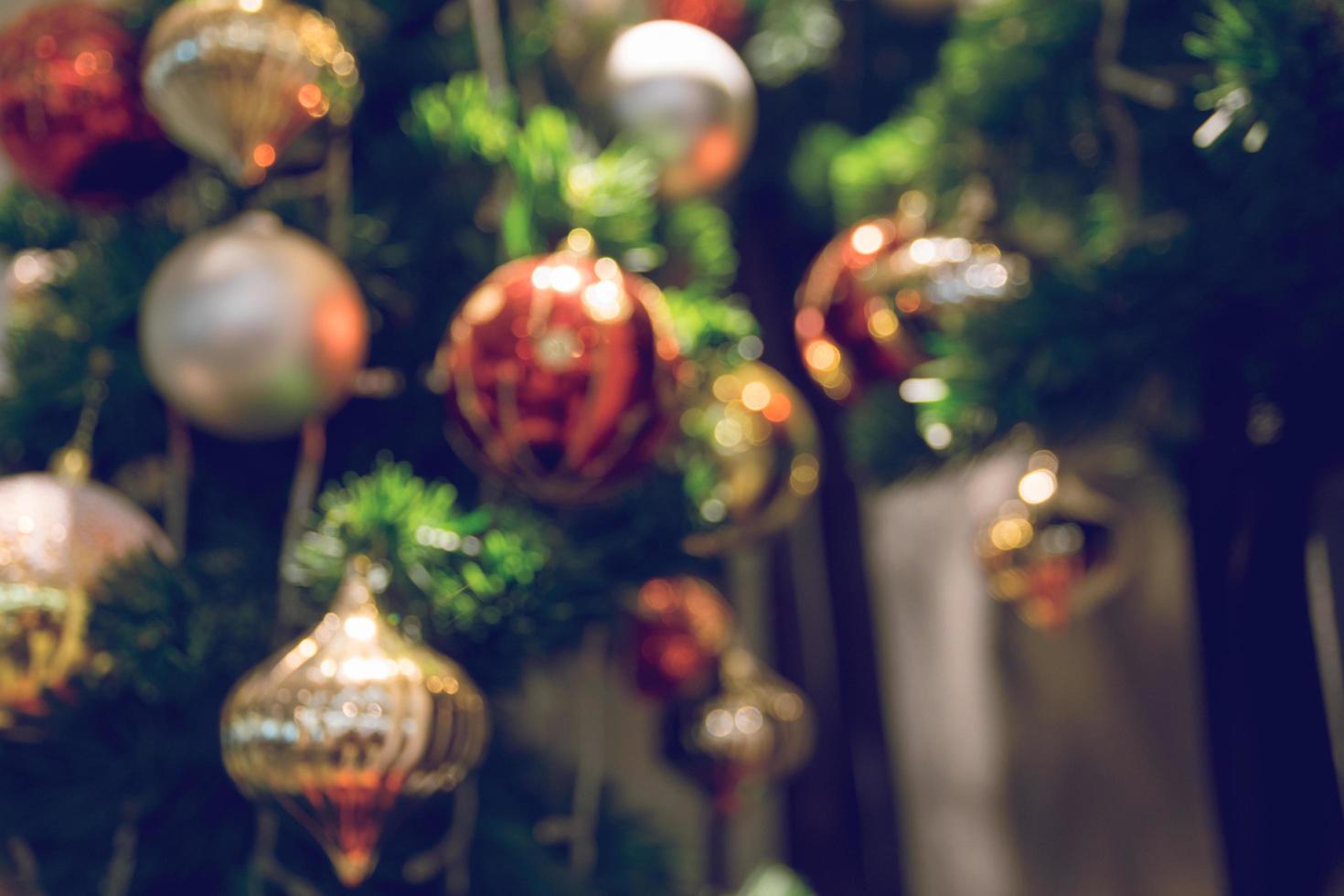 kerstbal die aan een versierde kerstboom hangt. vervaging en retro filtereffect. foto