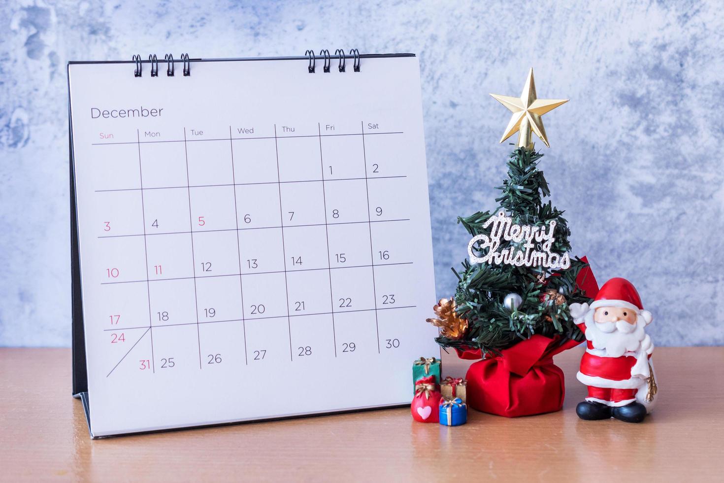 december kalender en kerstversiering - kerstman, boom en cadeau op houten tafel. Kerstmis en gelukkig nieuwjaar concept foto