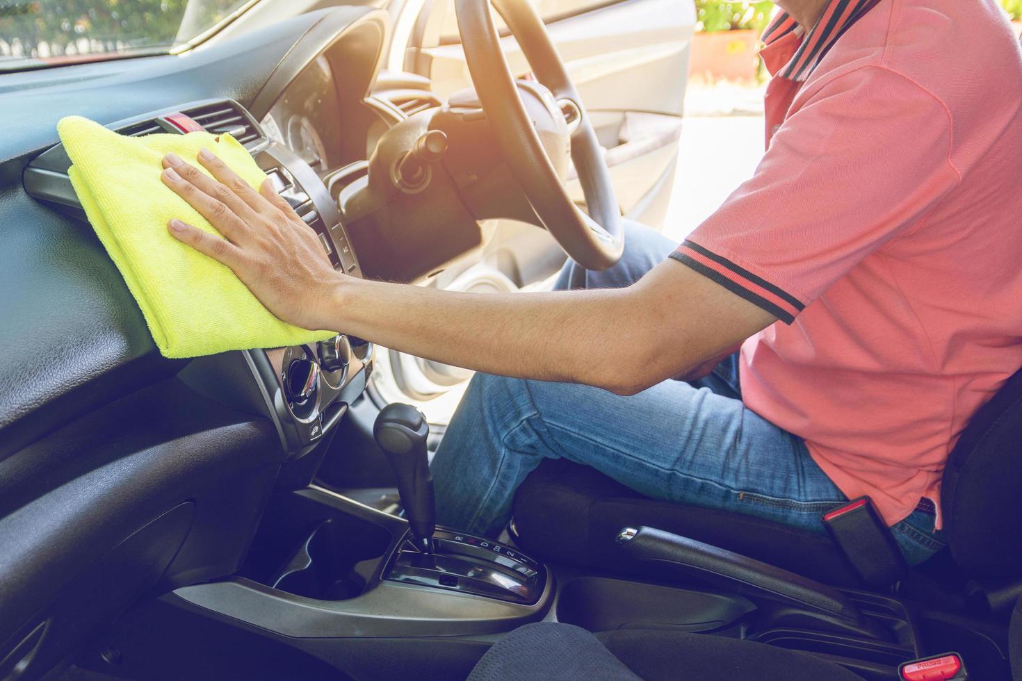 man die auto schoonmaakt met microvezeldoek foto