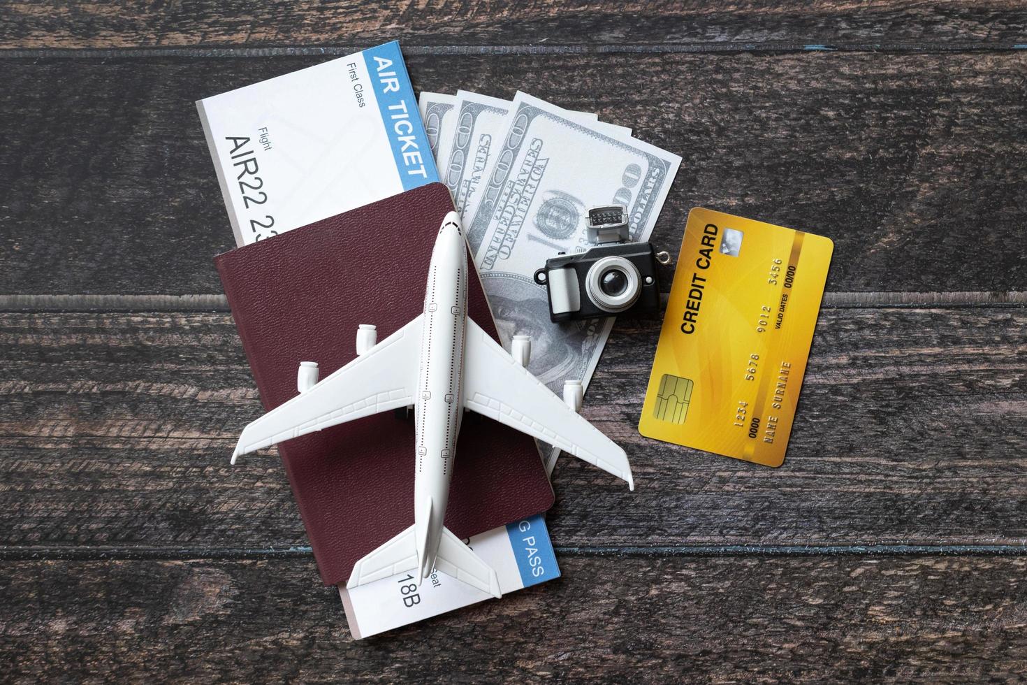 speelgoedvliegtuig, vliegticket, creditcards, dollars en paspoort op houten tafel. reisconcept foto