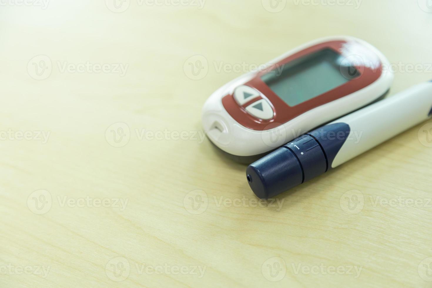 close-up van glucosemeter met lancet op houten tafel en kopieer ruimte als medicijn, diabetes, glycemie, gezondheidszorg en mensenconcept. foto