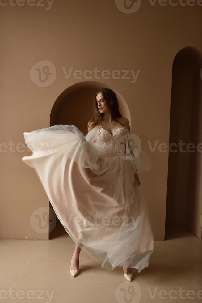 portret van een jonge mooie bruid in volle groei. meisje poseren in een kamer bij het raam. foto