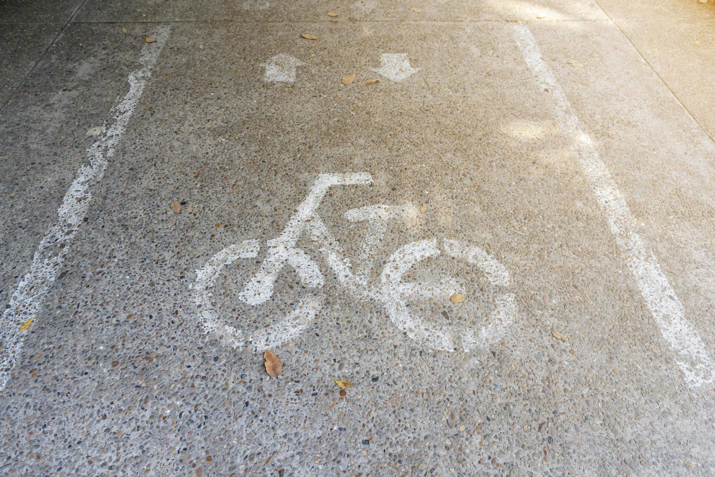 wit geschilderd fietsbord op de grond voor fietsen weg foto