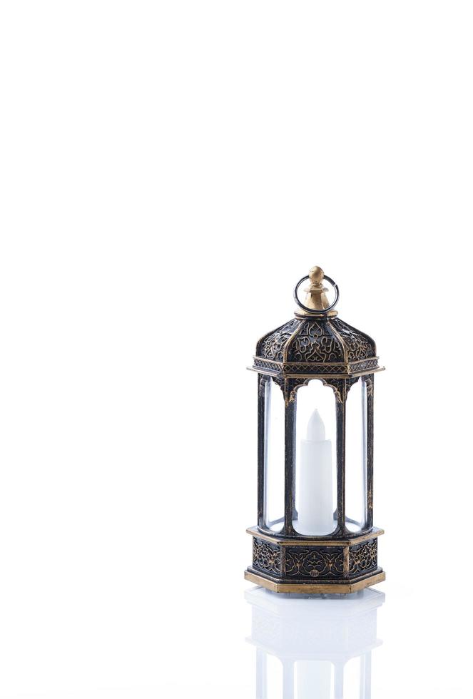 decoratieve Arabische lantaarn met brandende kaars gloeien op een witte achtergrond. foto