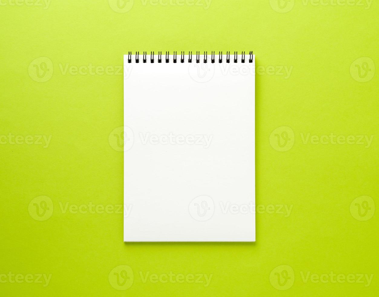 lege Kladblok witte pagina op groen bureau, kleur achtergrond. bovenaanzicht, lege ruimte voor tekst. foto
