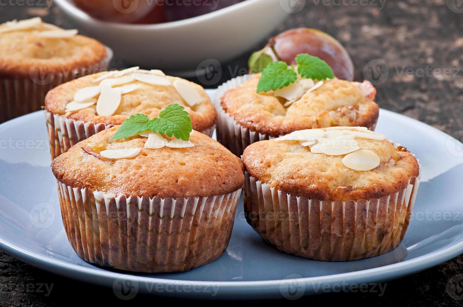 muffins met pruimen en amandelblaadjes versierd met muntblaadjes foto