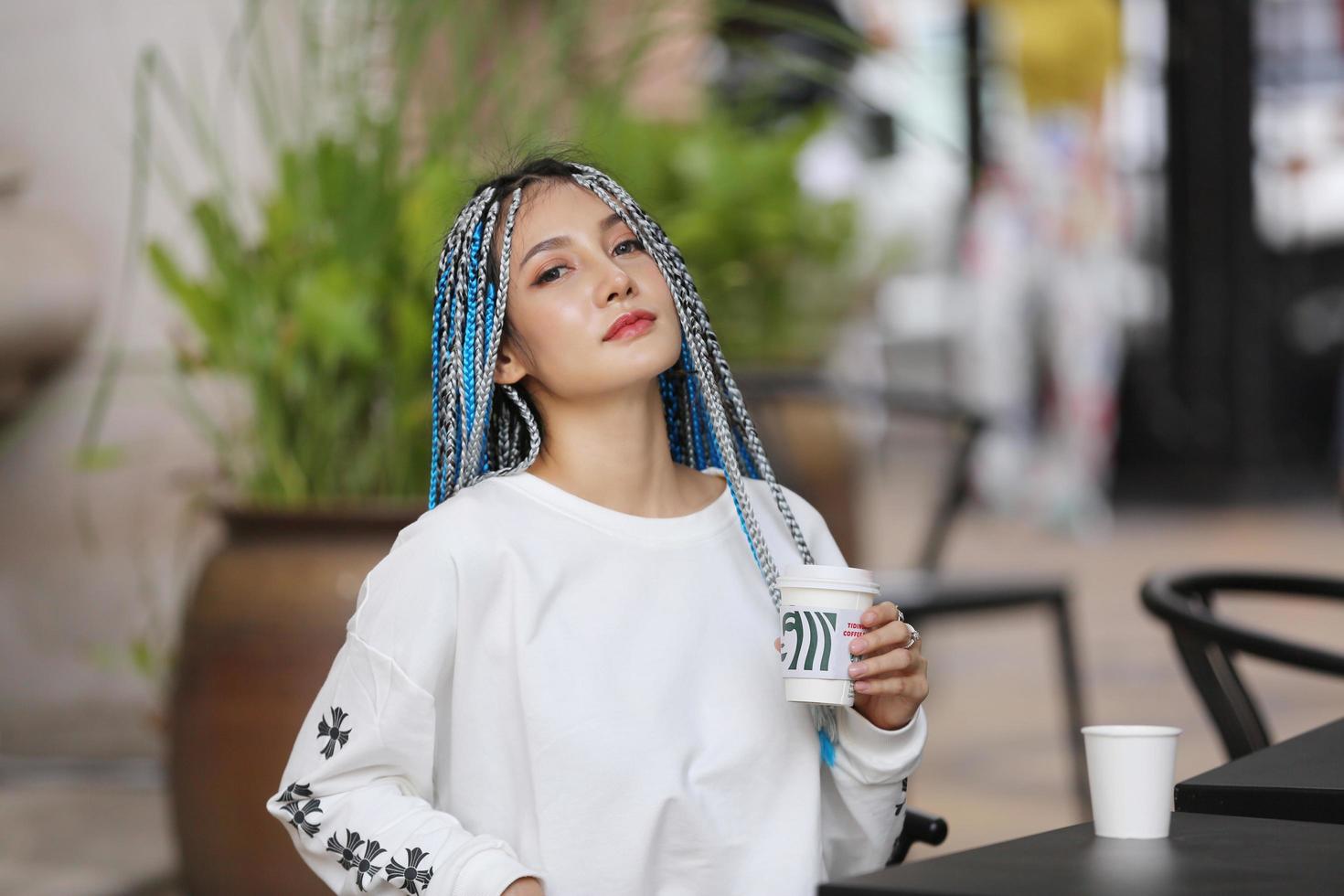 portret van een jong meisje met blauw haar, tiener die op straat staat als stadsleven. foto