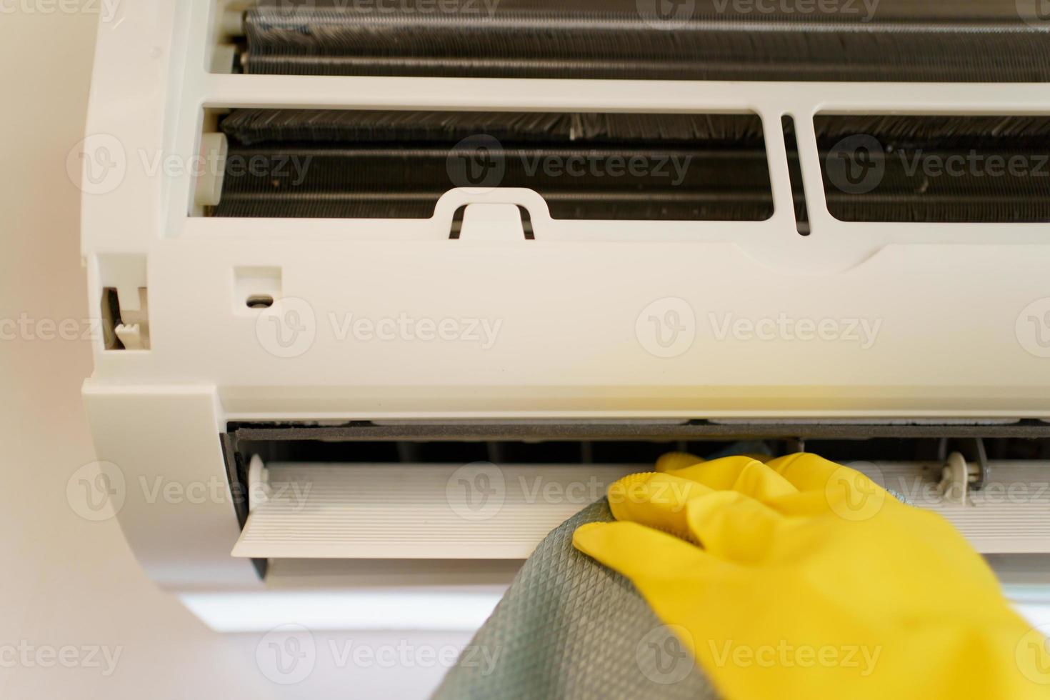 aziatische vrouw die een vuil en stoffig airconditioningfilter in haar huis schoonmaakt. huisvrouw die een stoffig airconditionerfilter verwijdert. foto