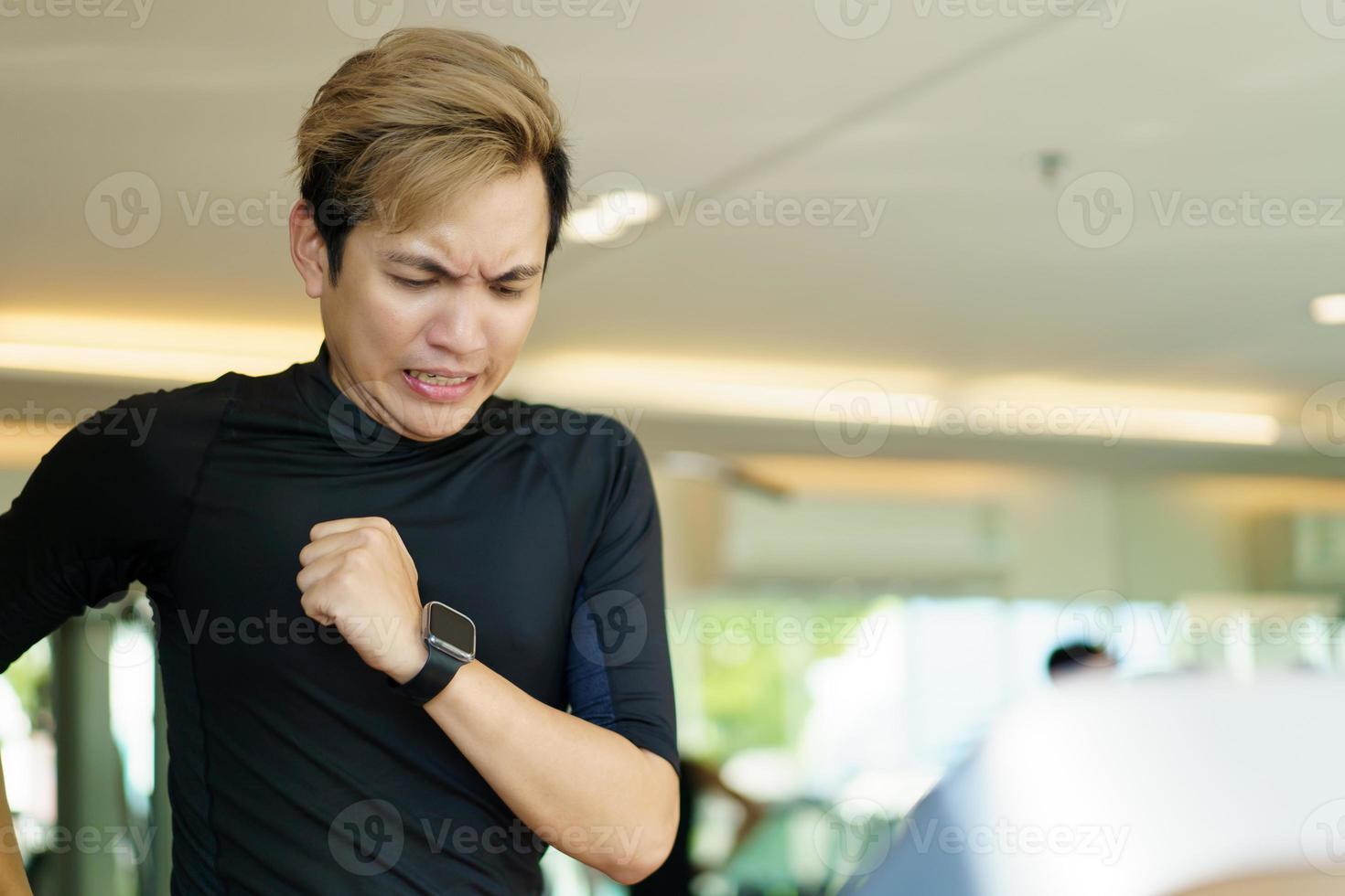 Aziatische knappe jongeman die een cardiotraining maakt door op de loopband in de sportschool te rennen. foto