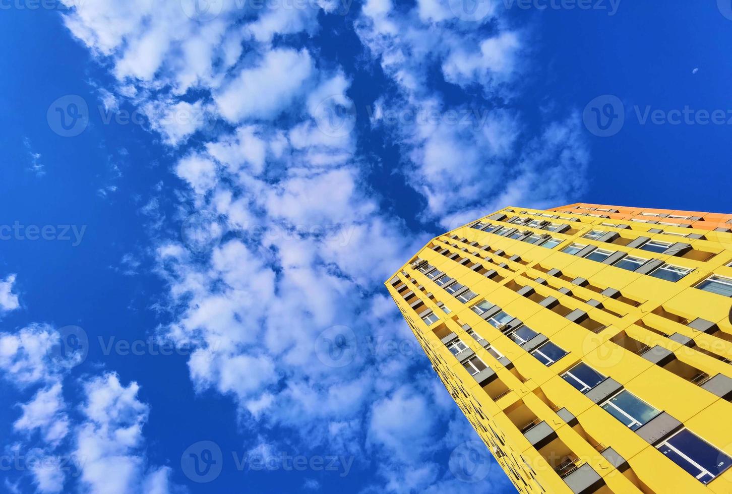 het gele gebouw en de blauwe lucht, witte wolken foto