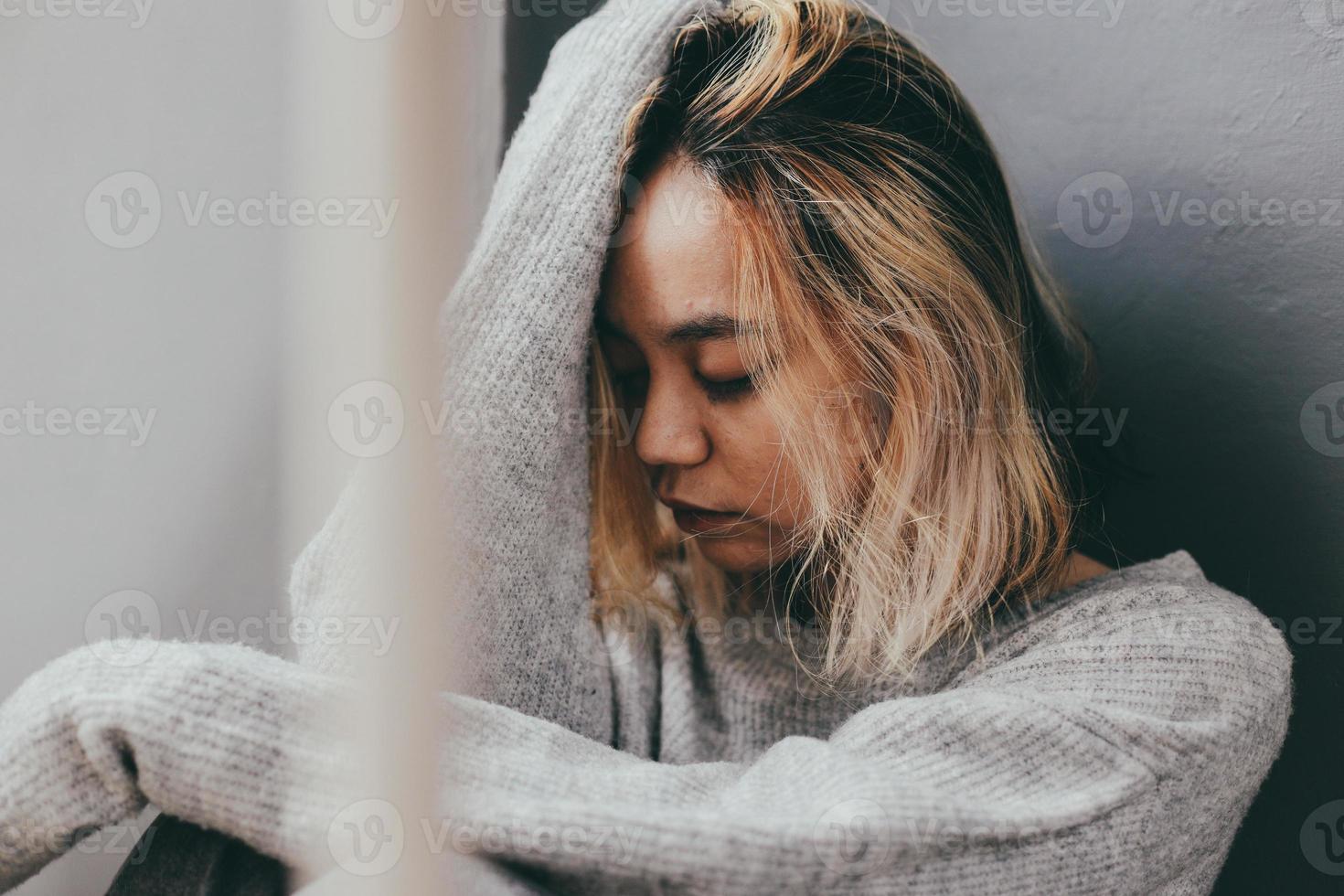 depressieve en verdrietige jonge vrouw die alleen thuis zit foto