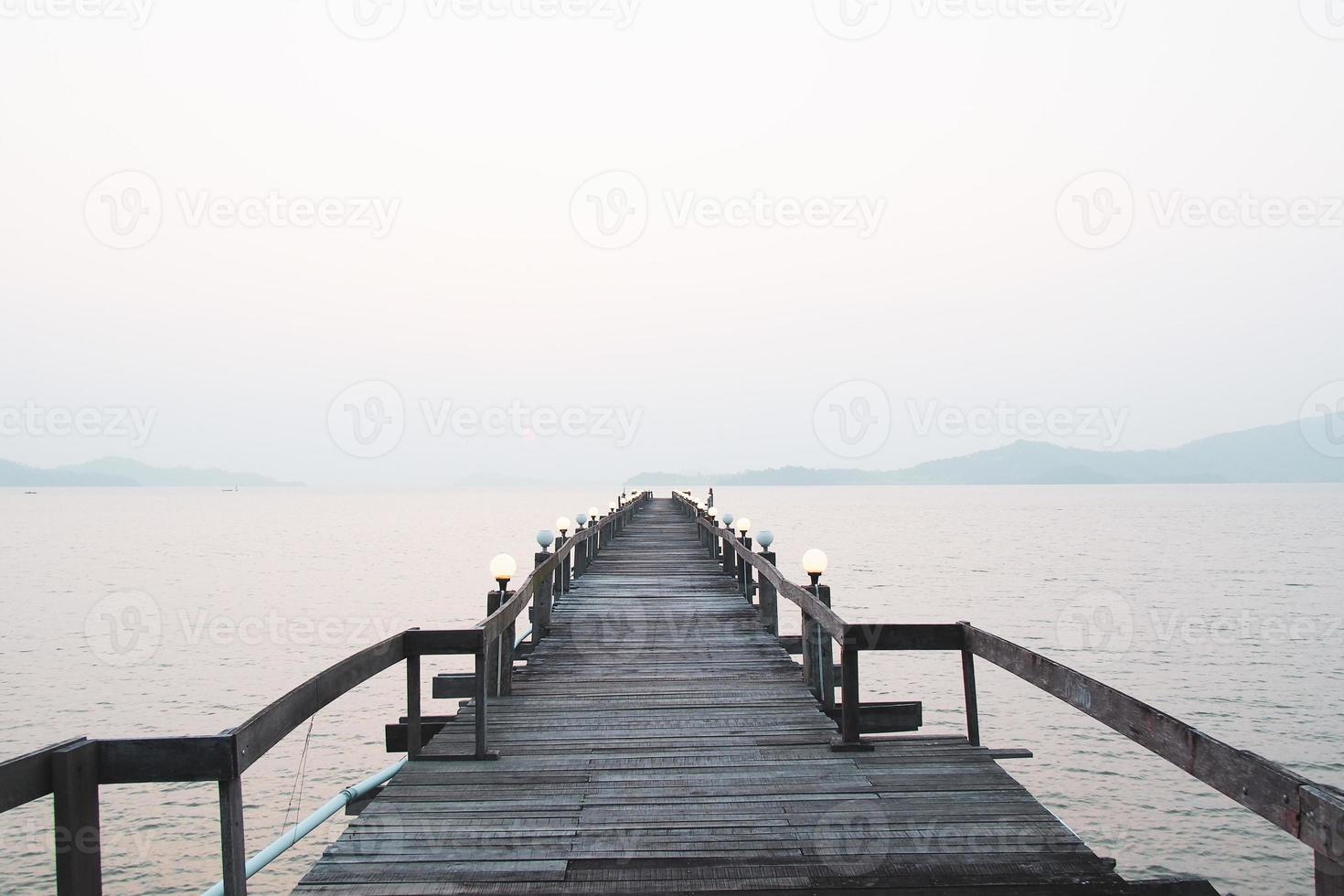 een houten loopbrug die zich uitstrekt in de zee. vakantie reisconcept foto