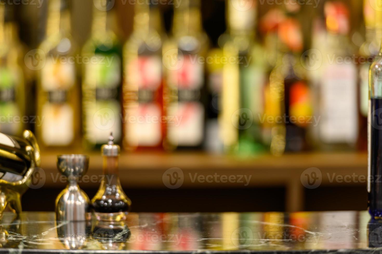 zwart marmeren tafelblad en prachtige bokeh-planken met alcoholflessen foto