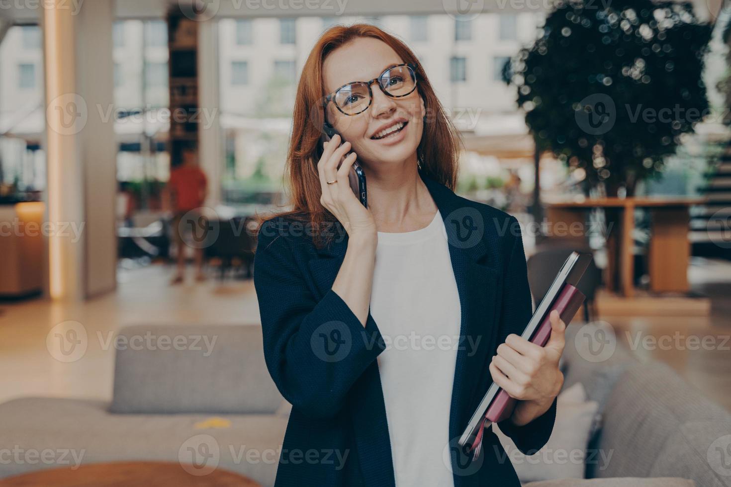 zelfverzekerde succesvolle gember vrouwelijke ondernemer genieten van aangenaam gesprek op mobiele telefoon foto