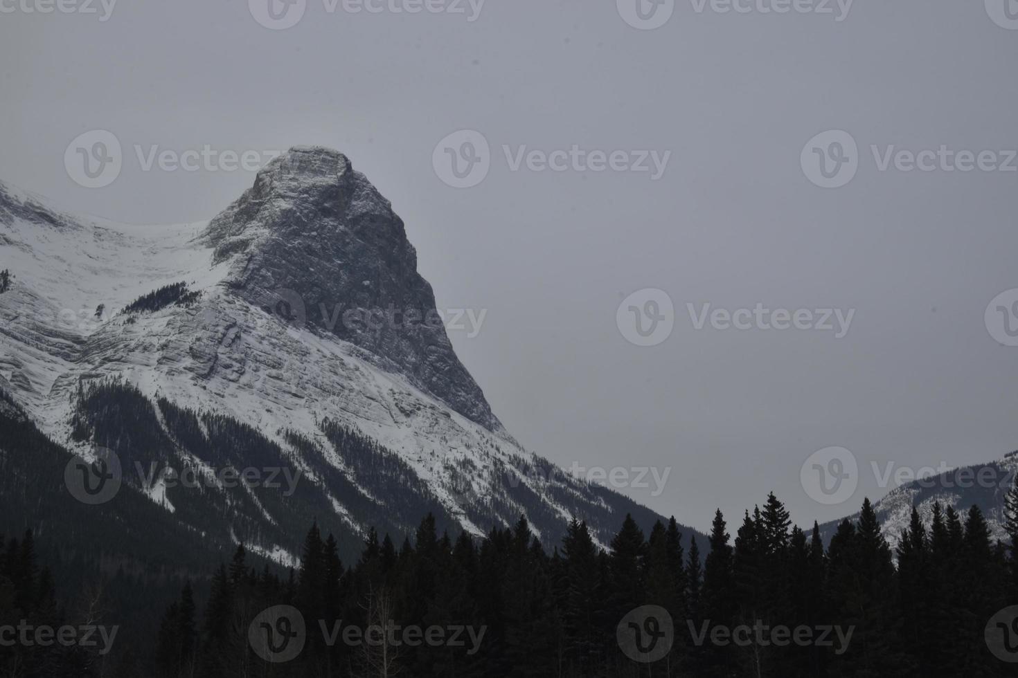 besneeuwde rotsachtige bergen met wazige grijze lucht foto