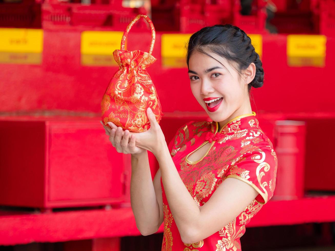 Aziatische vrouwen in Chinese klederdracht houden een wenskaart vast voor het Chinese nieuwjaarsevenement foto