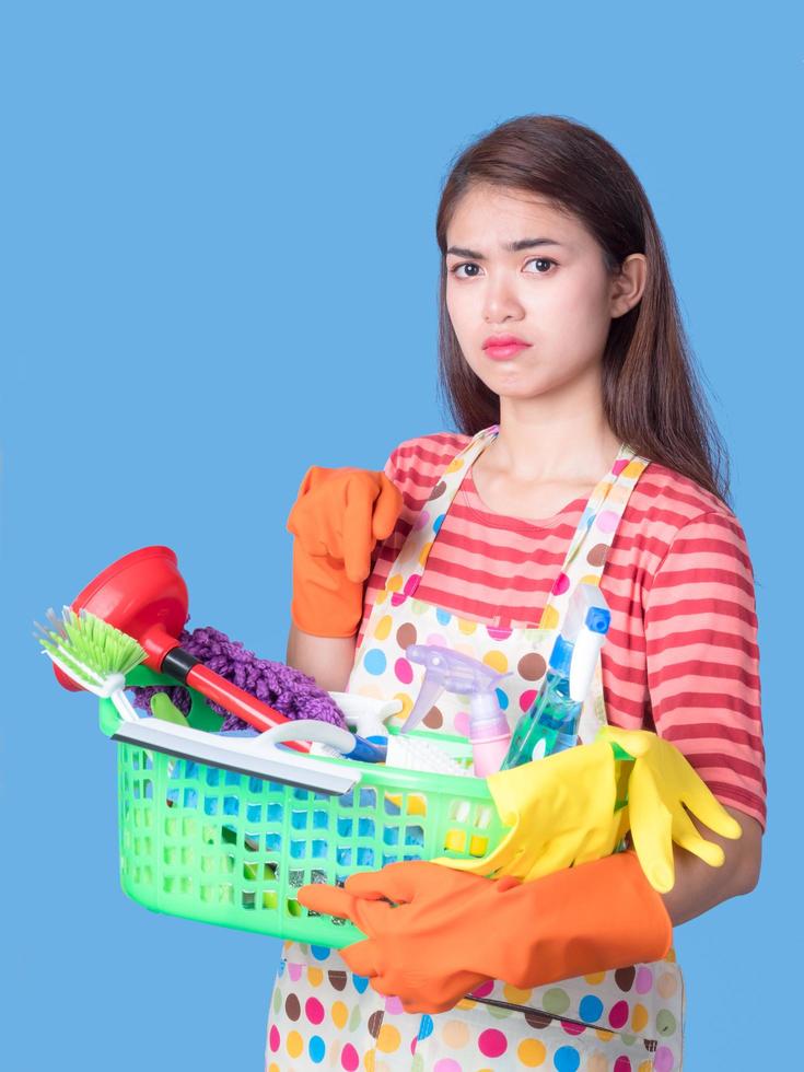 Aziatische mooie vrouwen die een mand vasthouden om het apparaat met vermoeidheid schoon te maken om het huis schoon te maken foto