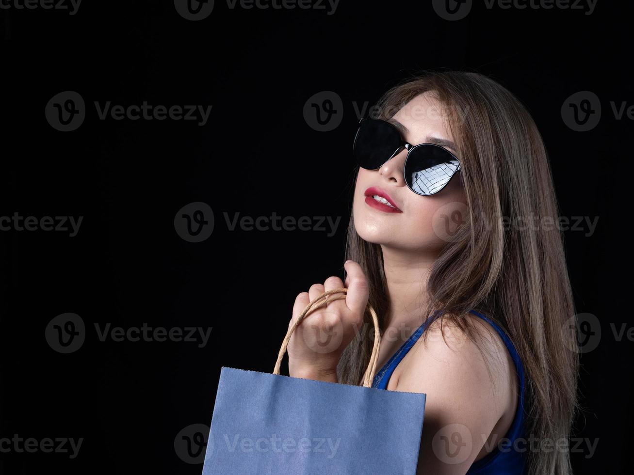 een mooie Aziatische vrouw in een blauwe jurk is blij om te gaan winkelen foto