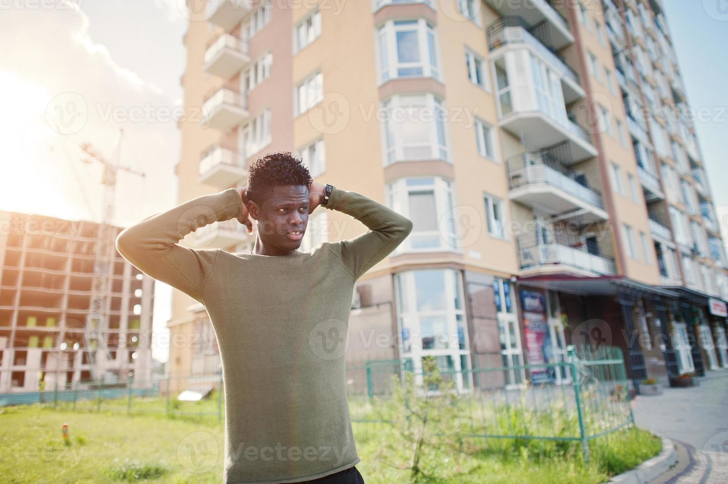 knappe en aantrekkelijke Afro-Amerikaanse man poseren naast het hoge gebouw op straat. foto