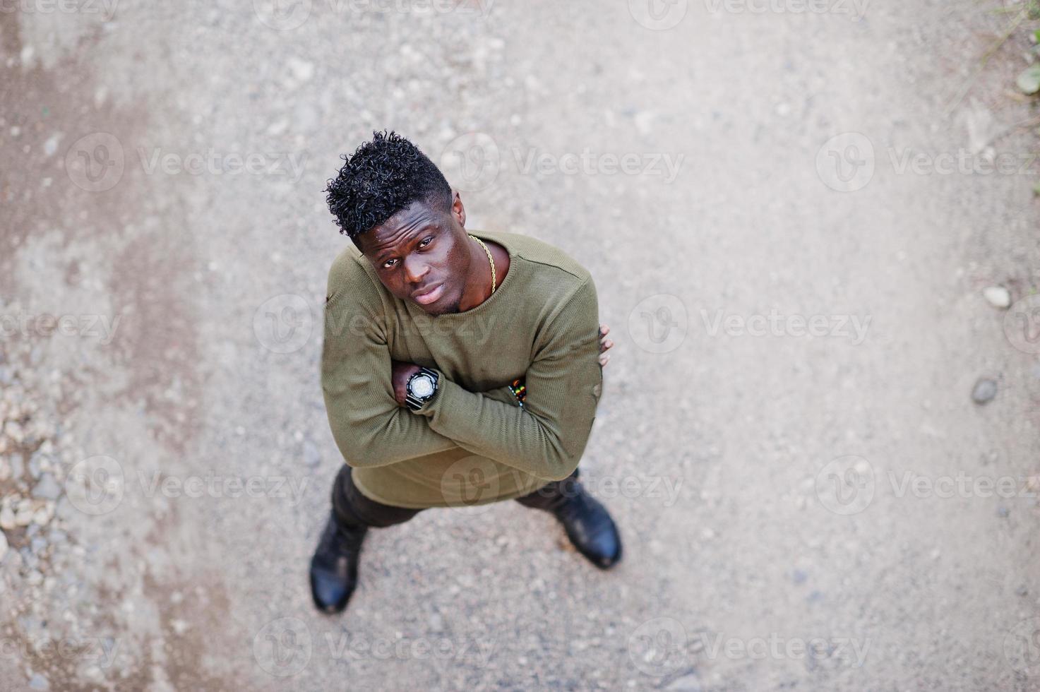 aantrekkelijke jonge Afro-Amerikaanse man in casual kleding staande op de onverharde weg. foto