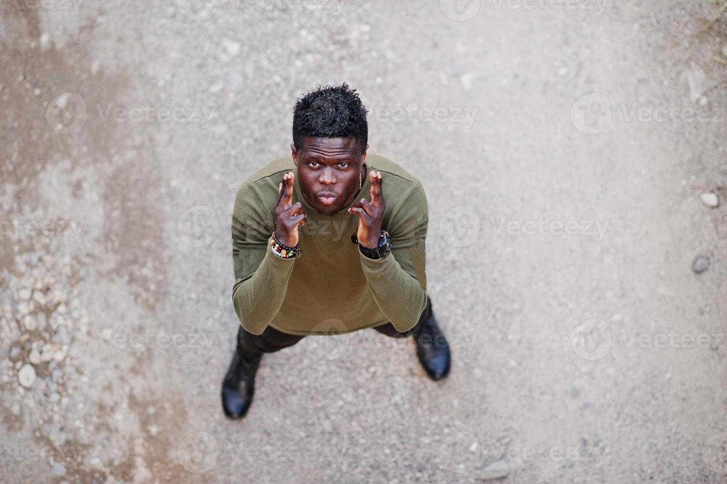 aantrekkelijke jonge Afro-Amerikaanse man in casual kleding staande op de onverharde weg. foto