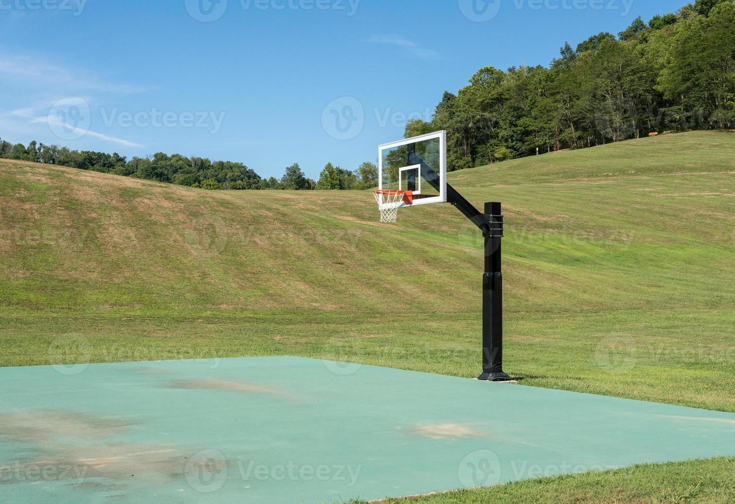 extern sportveld met basketbal- of korfbalnet omgeven door velden foto
