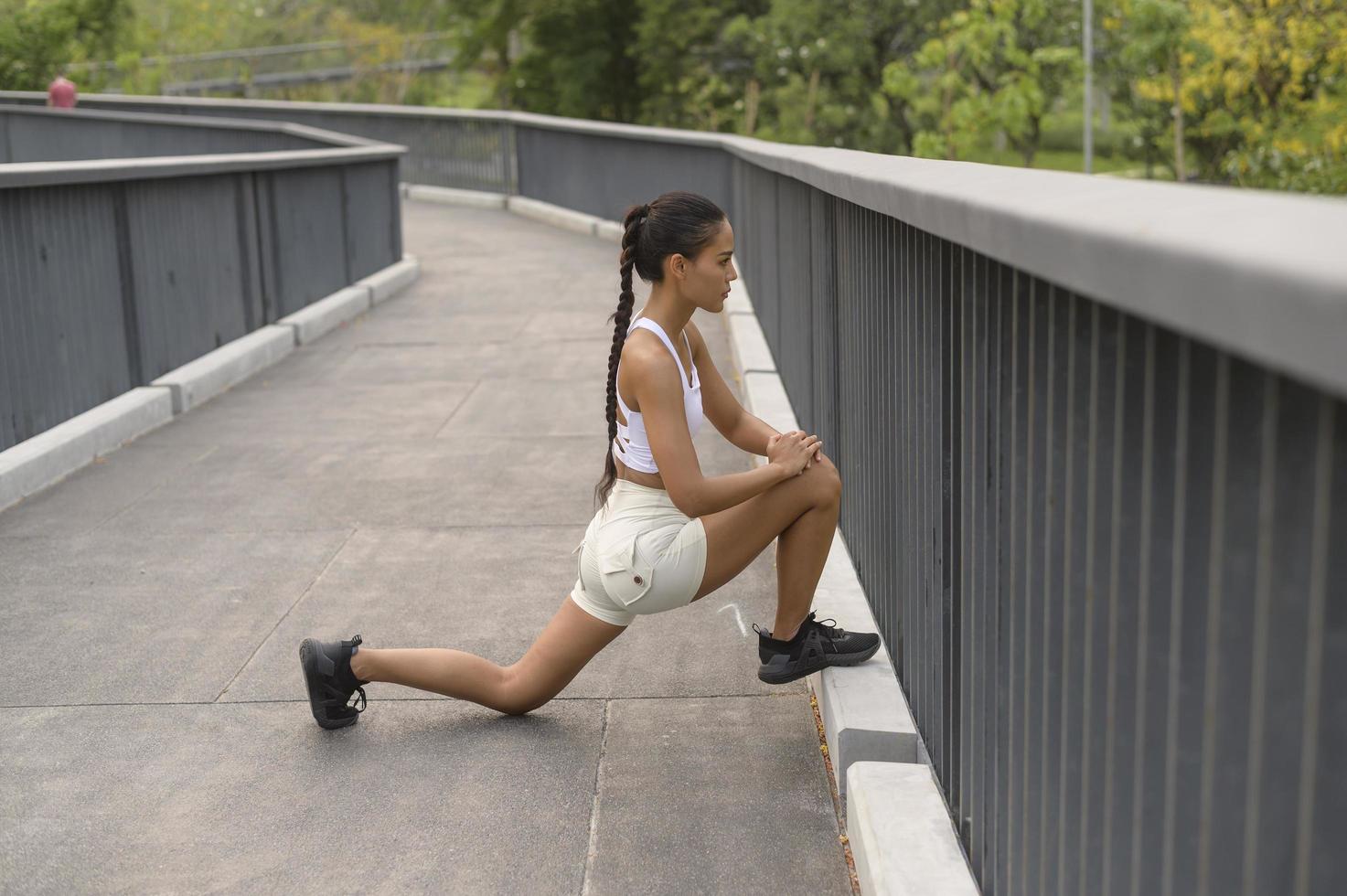 een jonge fitnessvrouw in sportkleding die traint in het stadspark, gezond en levensstijl. foto