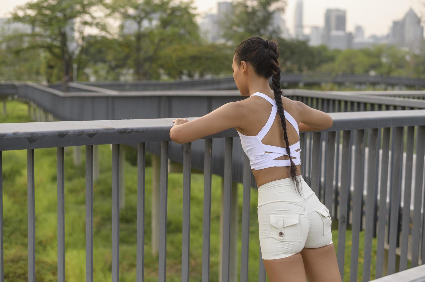 een jonge fitnessvrouw in sportkleding die traint in het stadspark, gezond en levensstijl. foto