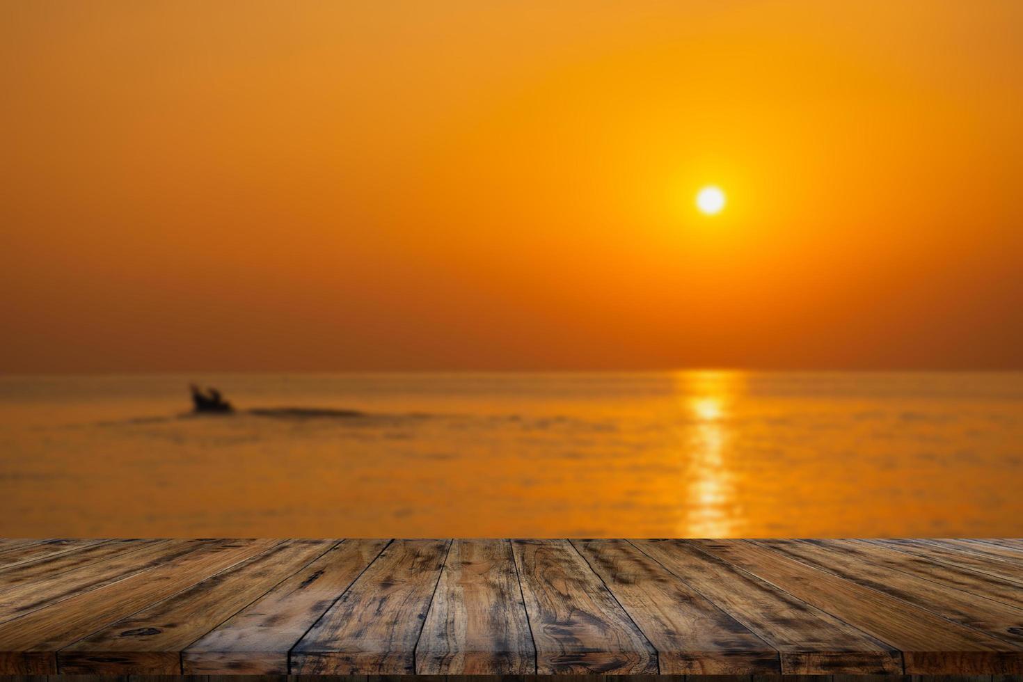 lege houten tafel op prachtige wazige zee zonsondergang foto