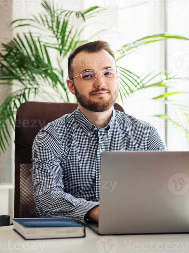 zakenman die op zijn laptop in een kantoor werkt foto