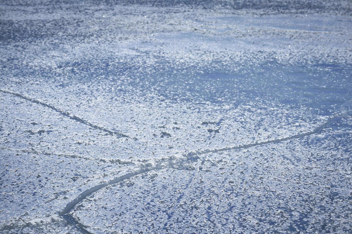 besneeuwd ijsoppervlak met scheuren in blauwe tinten en vignet foto