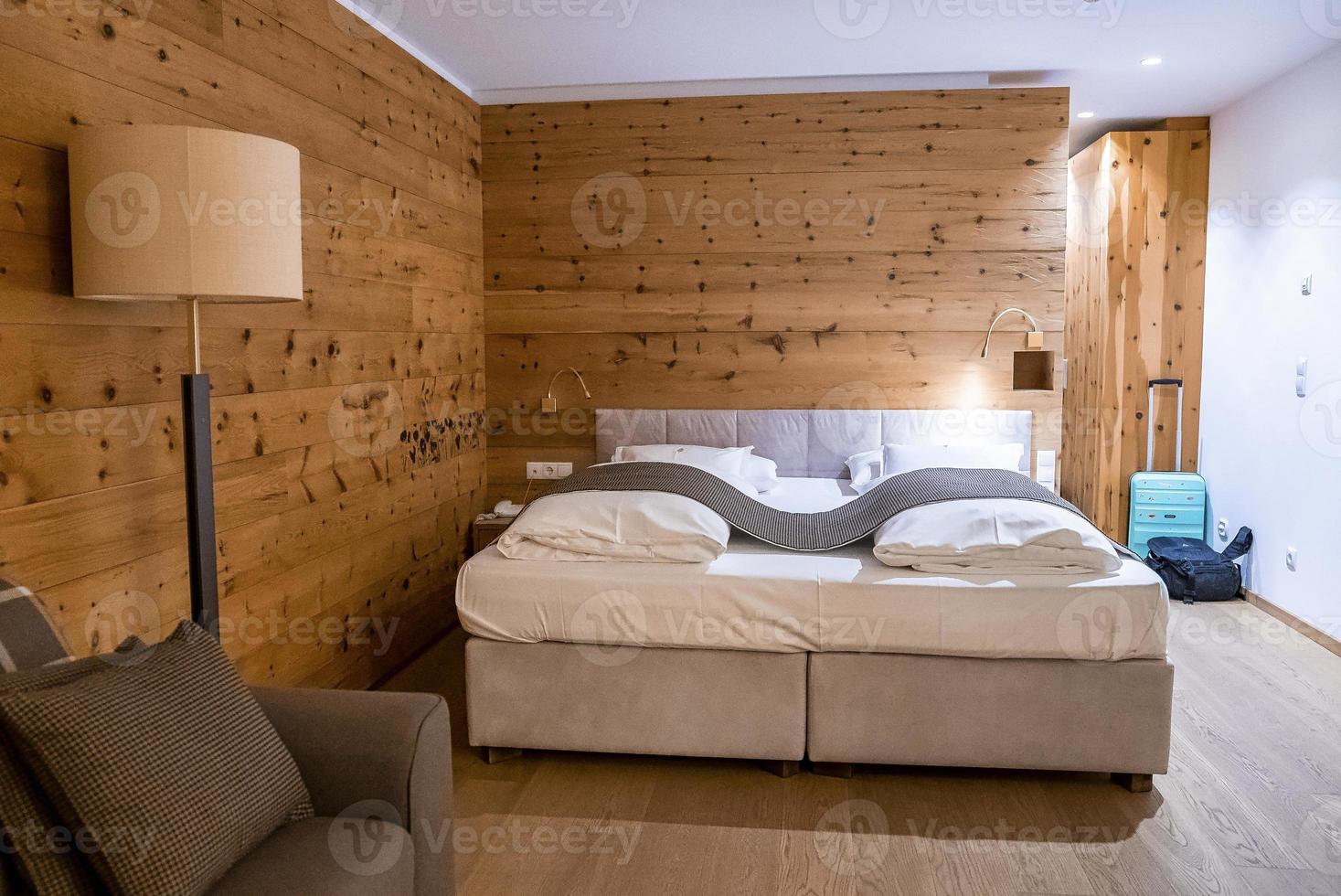 comfortabel bed in verlichte slaapkamer in rustieke stijl in luxe hotel foto