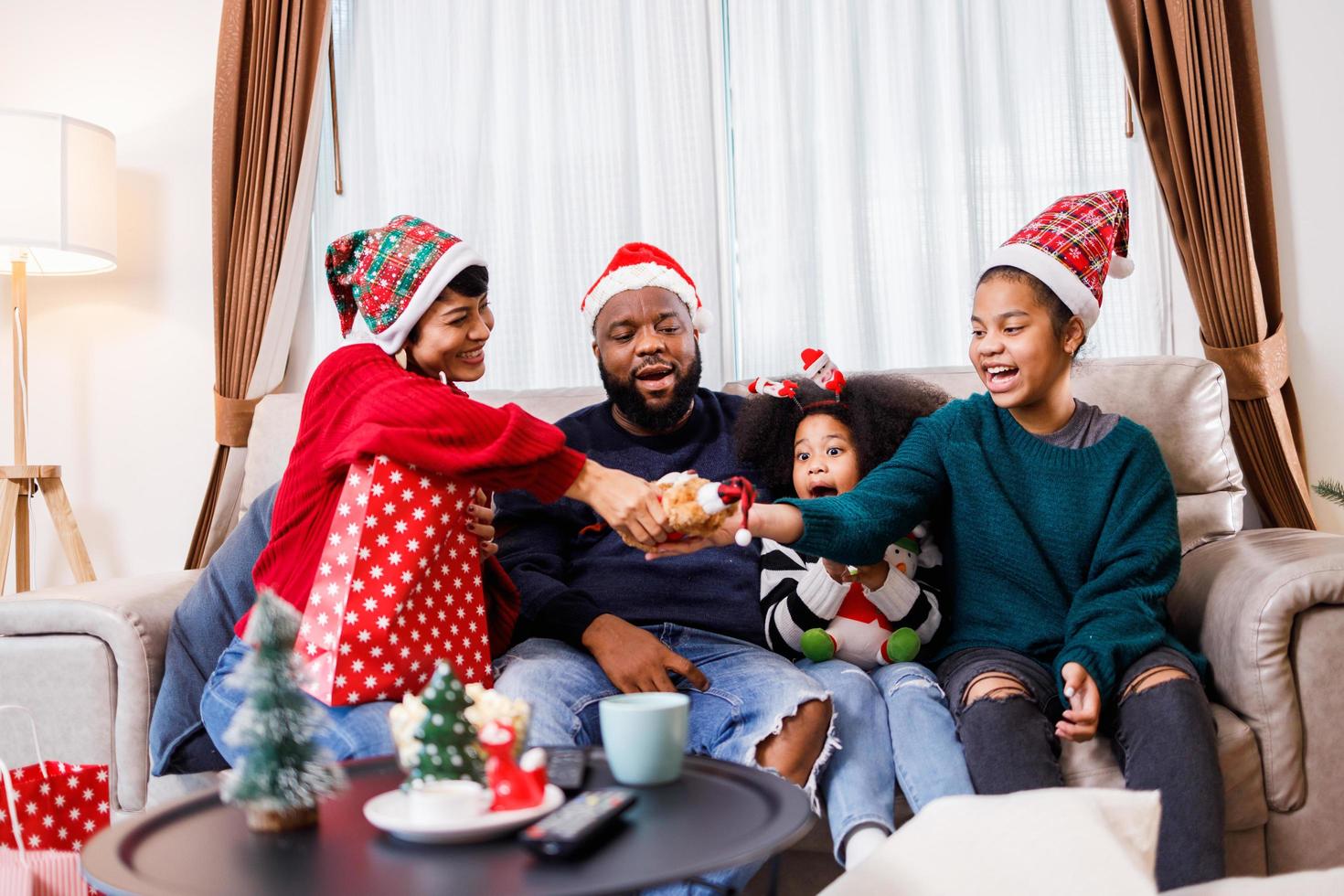afro-amerikaanse familie verrast met een cadeau op eerste kerstdag. Vrolijk Kerstfeest. foto