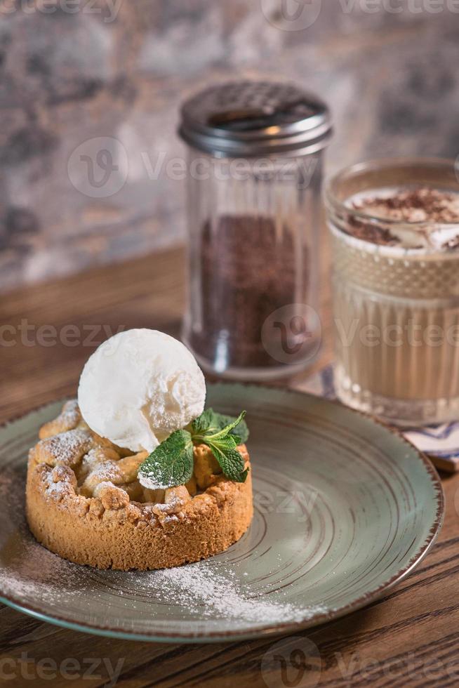 Apfelstrudel met ijs en munt op het bord en cocktail van witte melk op tafel foto