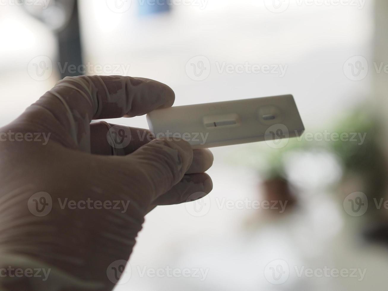 aziatische vrouw draagt rubberen handschoenen houd atk antigeen testkit covid-19 virustest vast foto