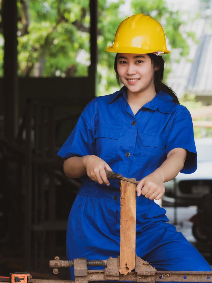 vrouwen die in mechanische uniformen werken door houtpolijstgereedschap te gebruiken om de planken aan te passen foto