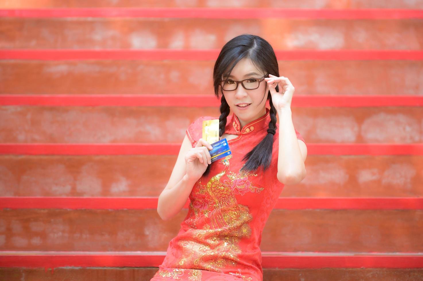 Aziatische vrouw in Chinese klederdracht heeft een creditcard om te winkelen foto