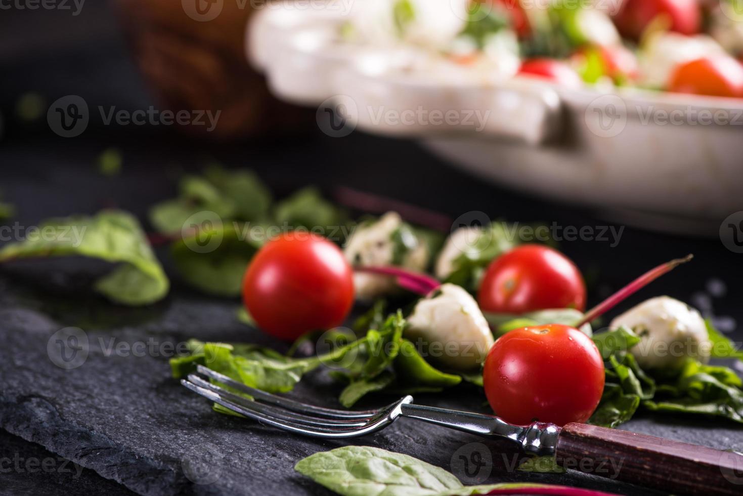 verse tomaat en mozzarella salade op zwarte leisteen foto