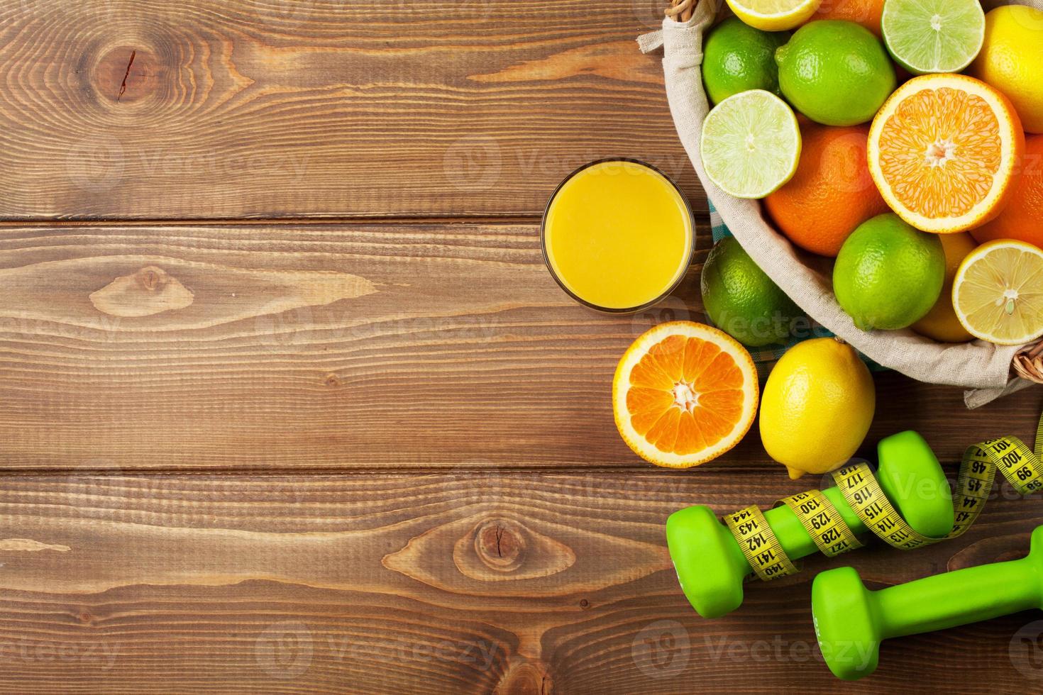 citrusvruchten in mand en dumbells. sinaasappels, limoenen en citroenen foto