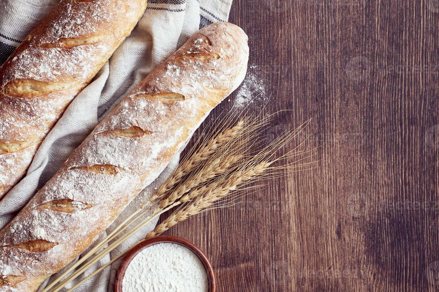 vers gebakken huisgemaakt knapperig brood baguette. twee broden op linnen handdoek foto